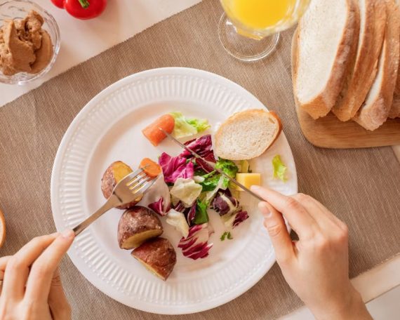 Top view of a nutritious breakfast setup with salad, bread, and fresh juice, perfect for a healthy start.